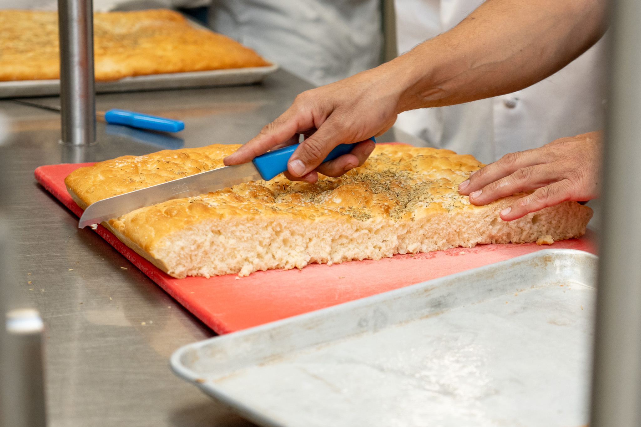 2026-10 CHEF RANDLE AWARD-15 Chef Trevor Randle cuts focaccia bread in the Maple Ridge Secondary teaching kitchen.