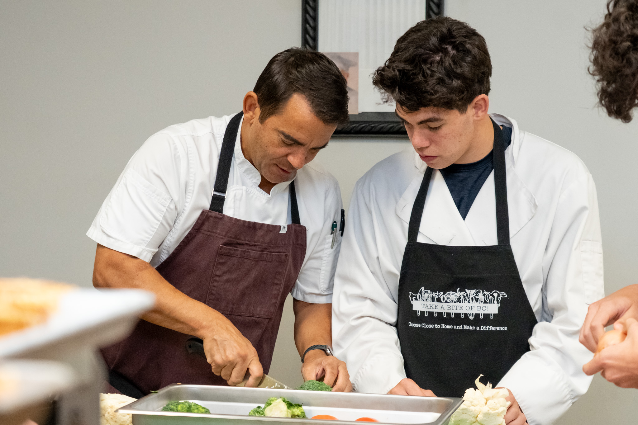 2026-10 CHEF RANDLE AWARD-21 Chef Trevor Randle assists a student in the Maple Ridge Secondary teaching kitchen.