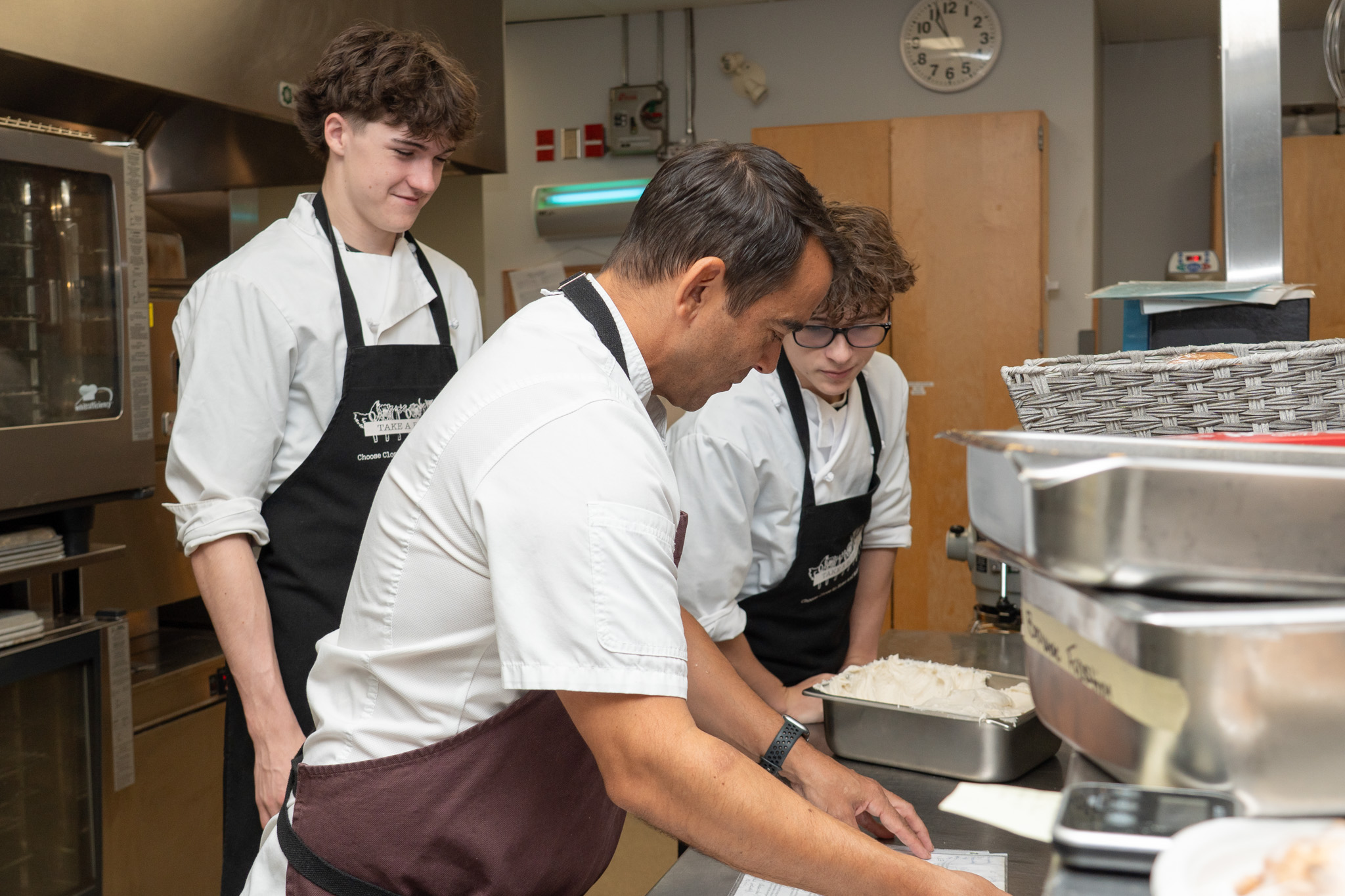 2026-10 CHEF RANDLE AWARD-7 Chef Trevor Randle assists students in the Maple Ridge Secondary teaching kitchen.