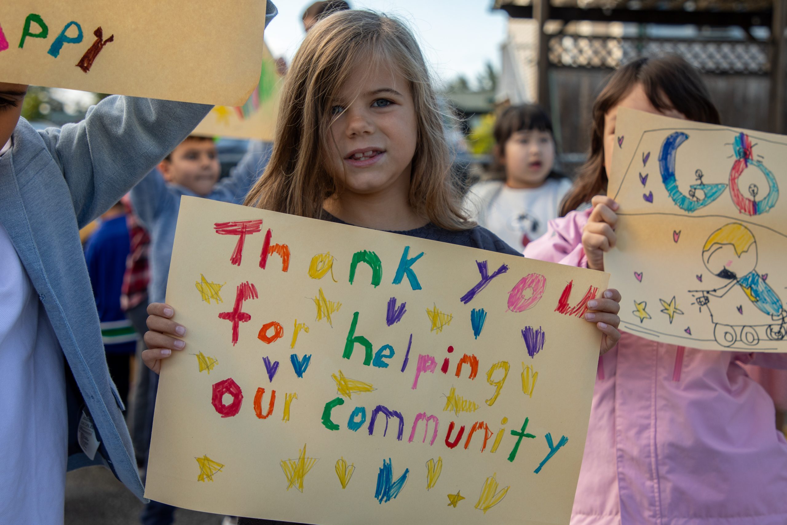 Student holds up sign at Albion Elementary cheering on the Cops for Cancer Tour de Coast.