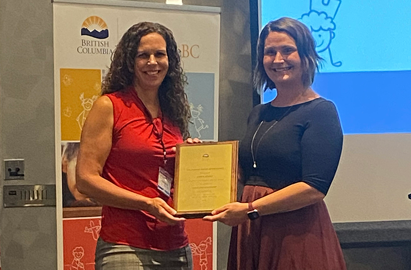 Karen LeSage, chair of the early childhood education program at Ridge Meadows College, is handed an award from Minister of State for Child Care Grace Lore on May 27, 2023.