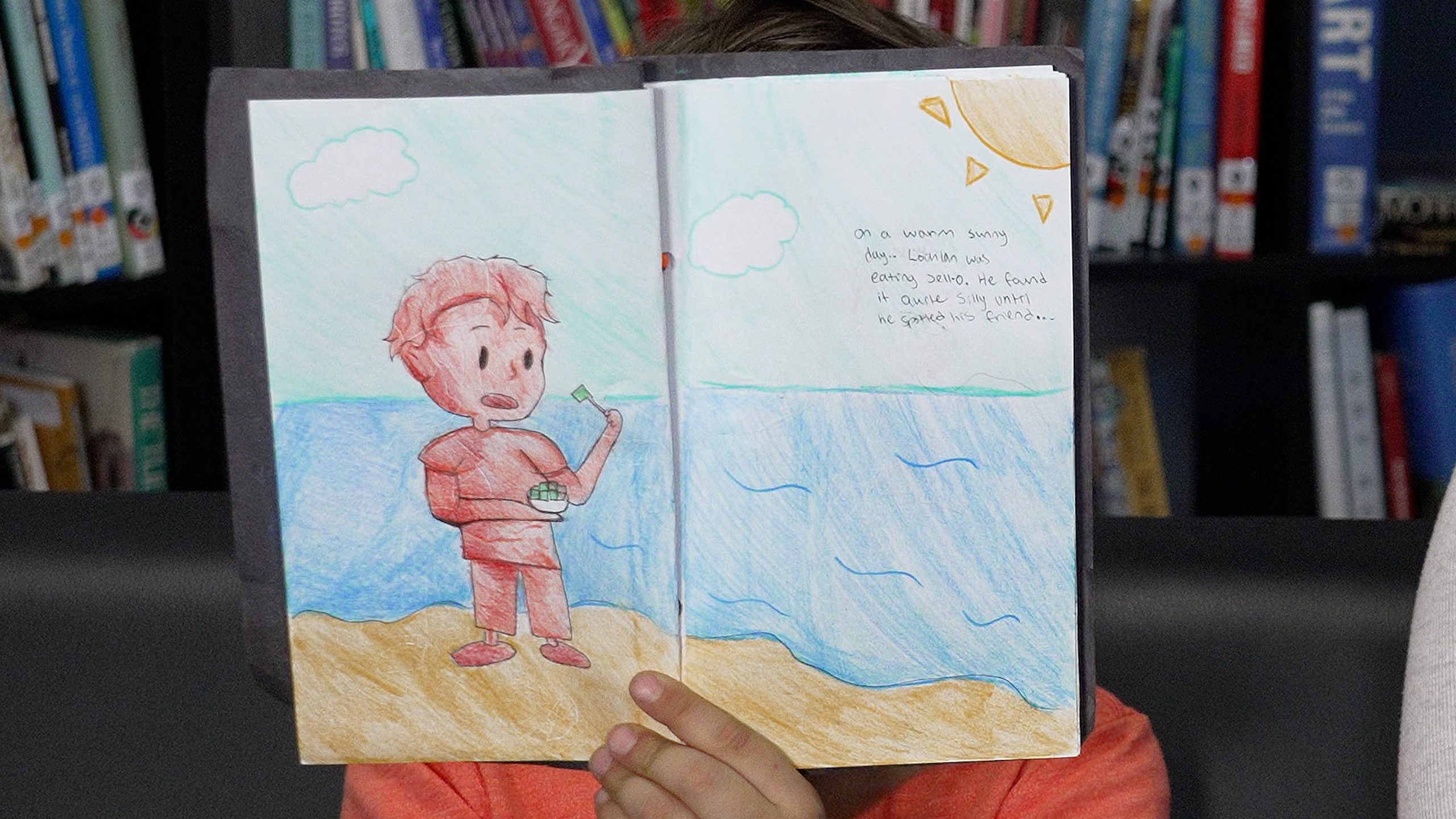 A Hammond Elementary student holds open a book written by a Westview Secondary student.