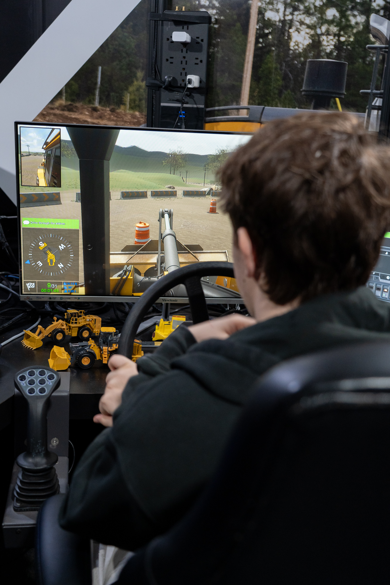Student tries out heavy equipment simulator at the 2026 SD42 Trades Showcase.