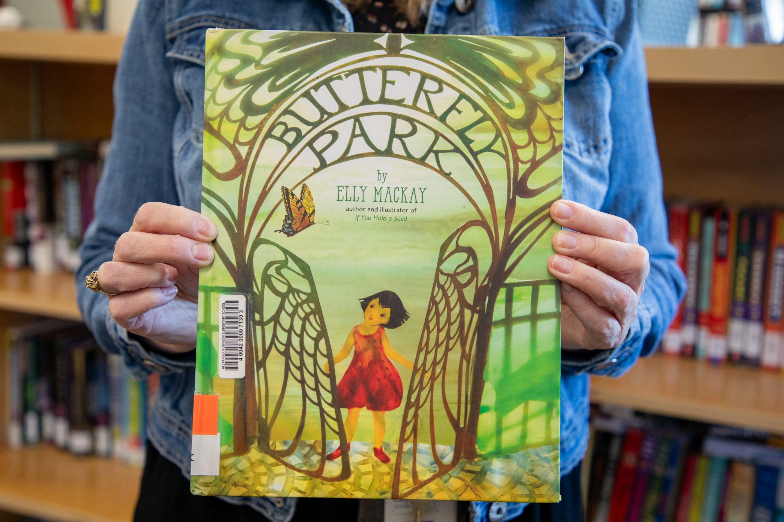 Alexander Robinson teacher-librarian Anita Neufeld holds up "Butterfly Park" by Elly MacKay.