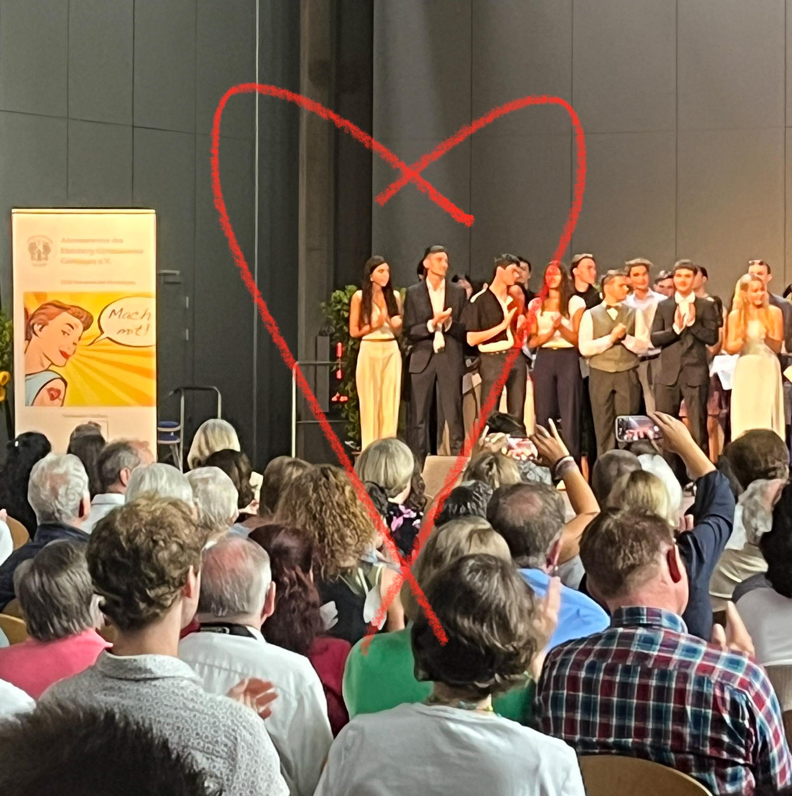 Pauline on the stage at her high school graduation ceremony in Germany with a heart drawn around her. 