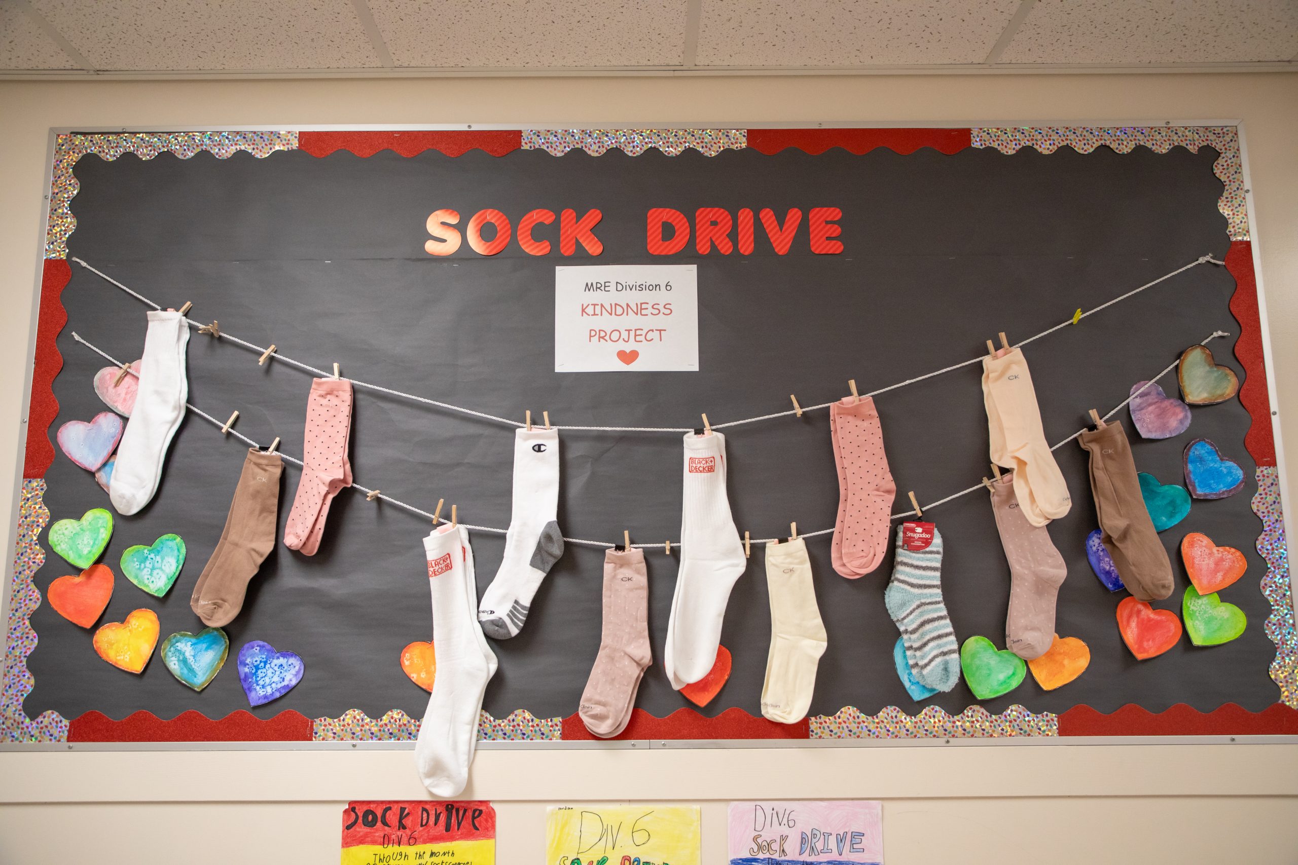 Bulletin board decorated with socks hanging from a clothesline.